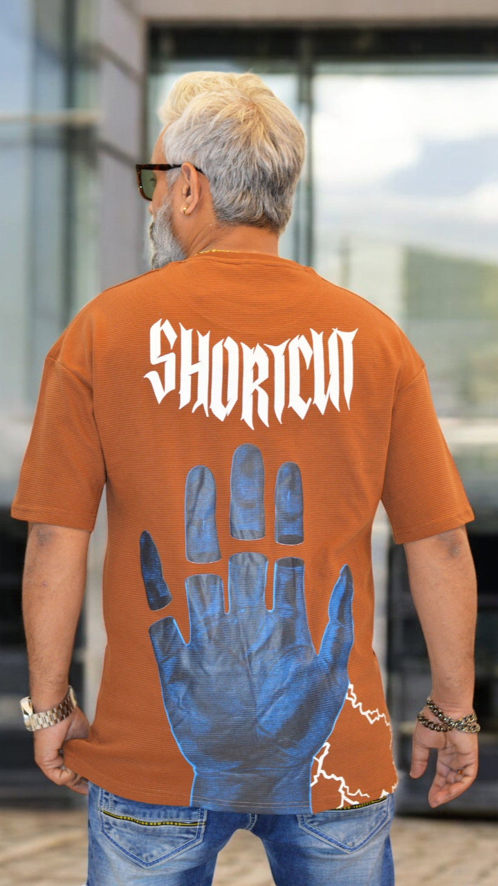 Back View: "Back view of rust oversized drop-shoulder T-shirt – Streetwear-inspired with high-quality puff print"
