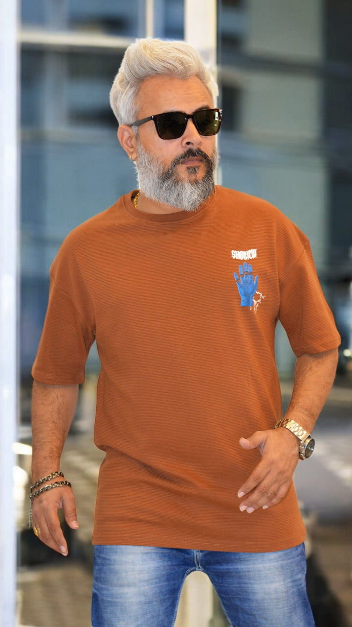Front View: "Rust oversized T-shirt for men – Premium textured fabric with bold puff print in streetwear style"
