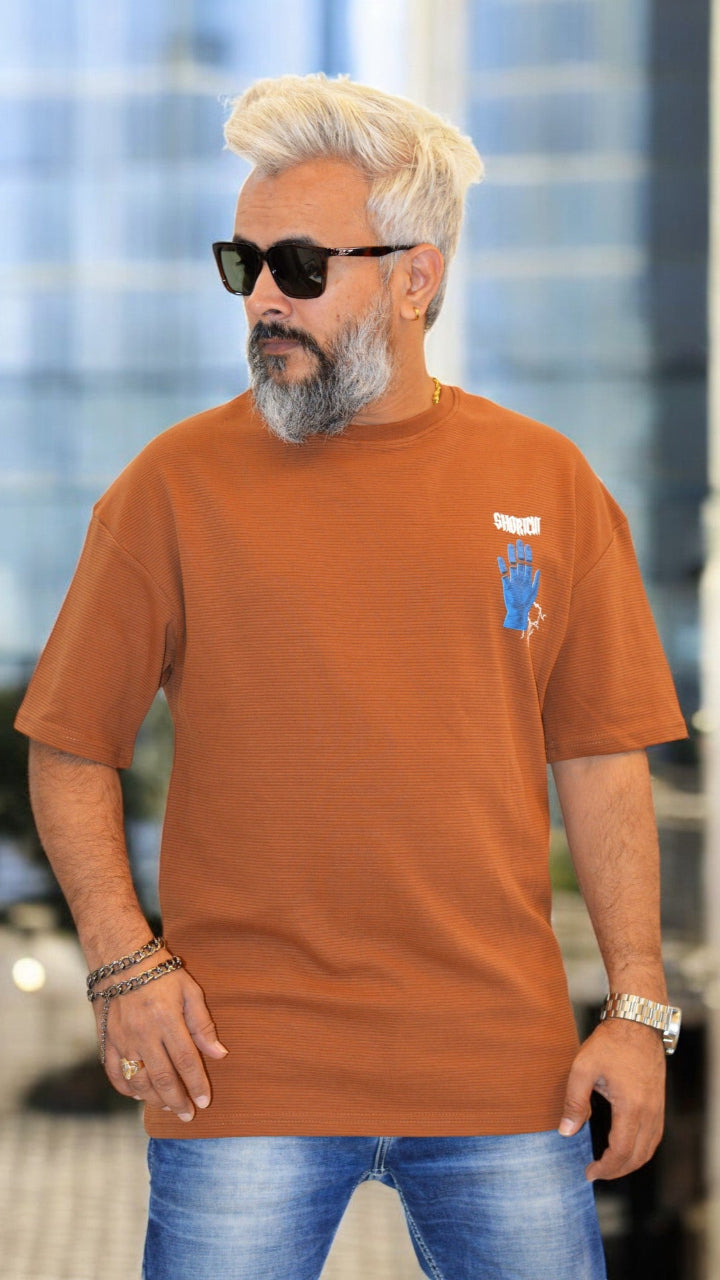 Side View: "Side profile of rust oversized T-shirt – Soft textured fabric and trendy puff print design"
