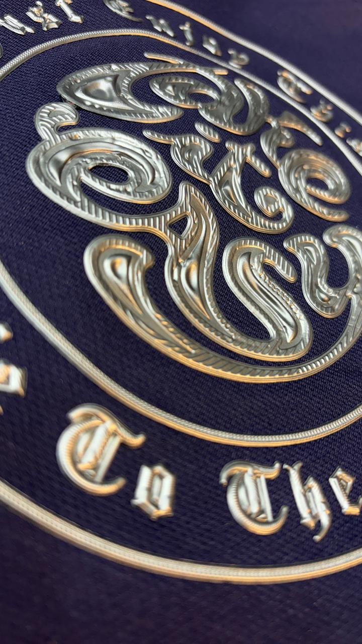 Close-up of a decorative emblem with intricate gold designs on a dark blue background