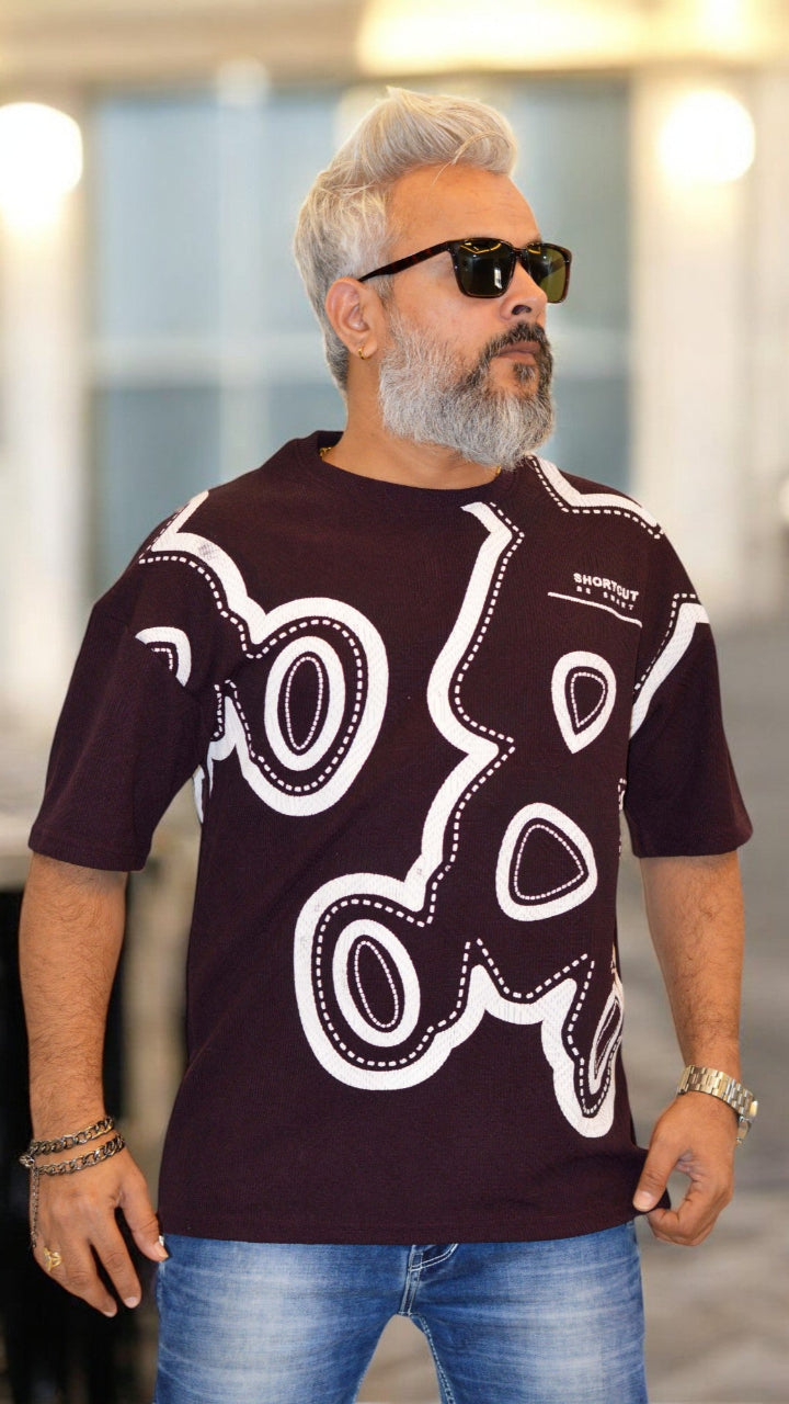 front view of black oversized drop-shoulder T-shirt with bold puff print design
